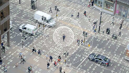 Computer code overlapping people walking in the street